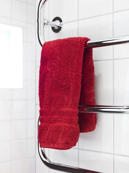 Красное полотенце на сушилке — стоковое фото