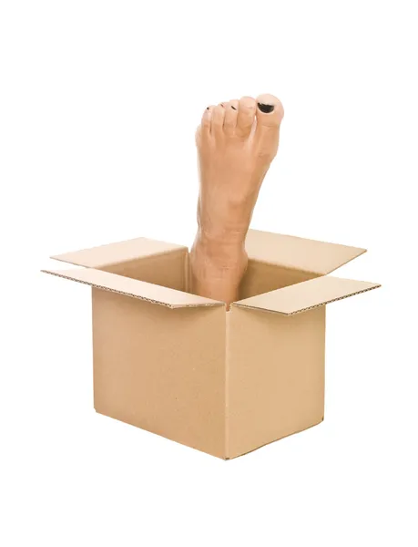 Emberi lábfej-ban egy karton doboz — Stock Fotó