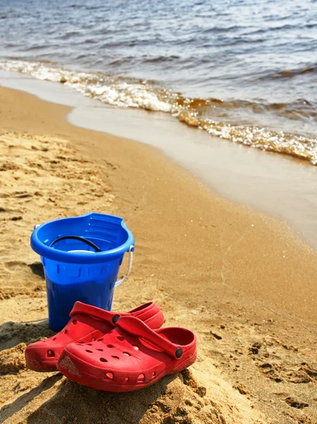 Красная вертикальная обувь на пляже — стоковое фото