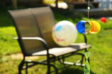 Pinwheel and loveseat in the backyard clipart