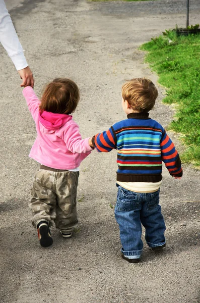 Toddlers walking away holding hands — Stock Photo, Image