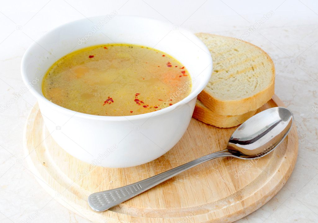 Vegetable / chicken soup with bread and spoon