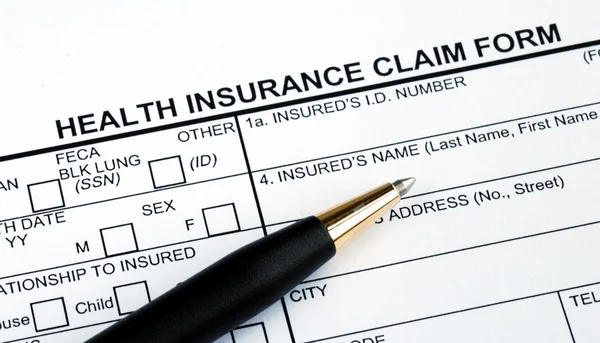 Remplissage du formulaire de demande d'assurance maladie — Photo