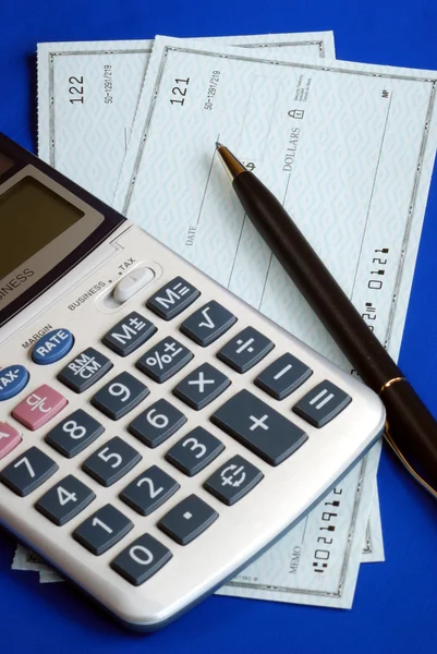 Sprawdź i płacić rachunki pisząc kontroli na niebieskim tle — Zdjęcie stockowe