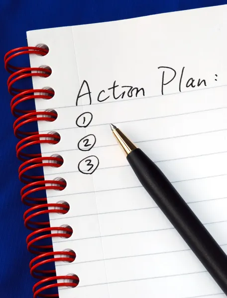 Utarbeta handlingsplanen i ett skrivblock som isolerad på blå — Stockfoto