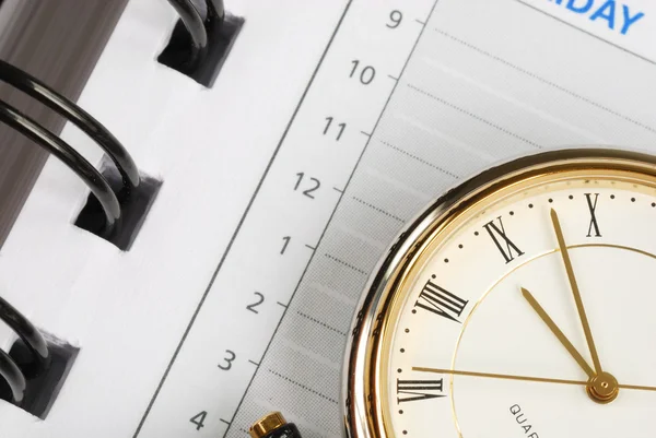 En närbild av klocka och dag planerare — Stockfoto