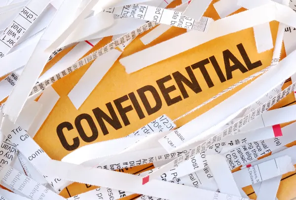 A palavra Confidencial cercada por alguns papéis desfiados — Fotografia de Stock