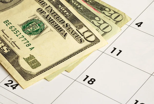 Pengar på en kalender begreppen finansiell planering — Stockfoto