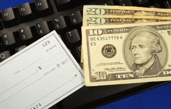 Наличные и чеки на клавиатуре - как заработать деньги в Интернете — стоковое фото