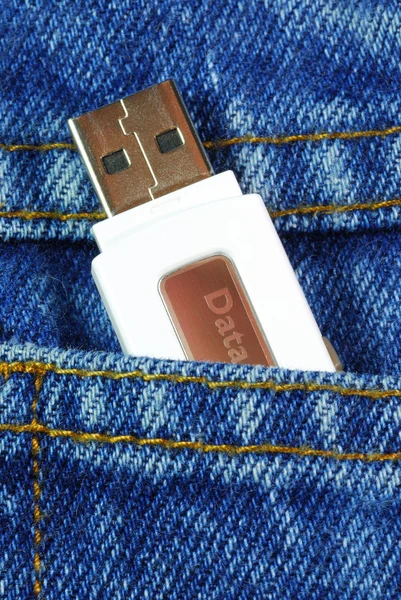 USB flash-geheugen schijf in een jeans zak concepten van gegevens mobiliteit springen — Stockfoto
