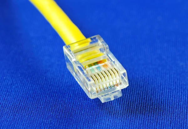 Detailní pohled na žlutý kabel Ethernet (Rj45), izolované na modré — Stock fotografie
