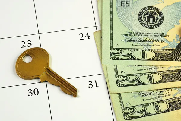 Clave y dinero en un calendario conceptos de pago de la hipoteca a tiempo — Foto de Stock