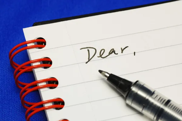 A palavra Caro com uma caneta conceitos de escrever uma carta isolada em azul — Fotografia de Stock