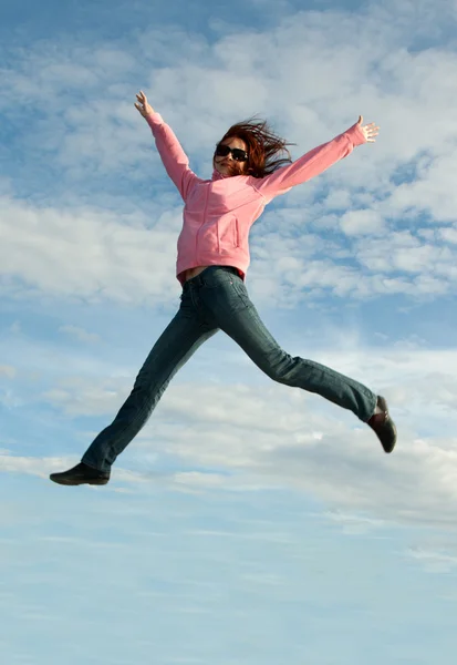 Дівчина в стрибку на фоні неба — стокове фото