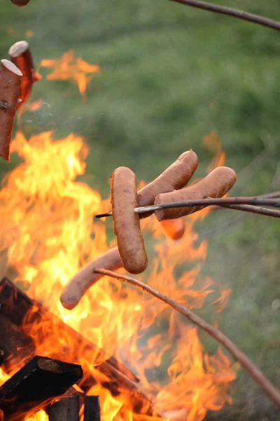 stock image Sausages roasting over fire flames