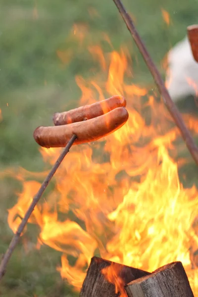 stock image Sausages roasting over fire flames