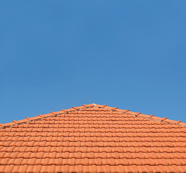 An orange-tiled rooftop against a clear blue sky.