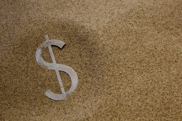 Доллар в песке — стоковое фото