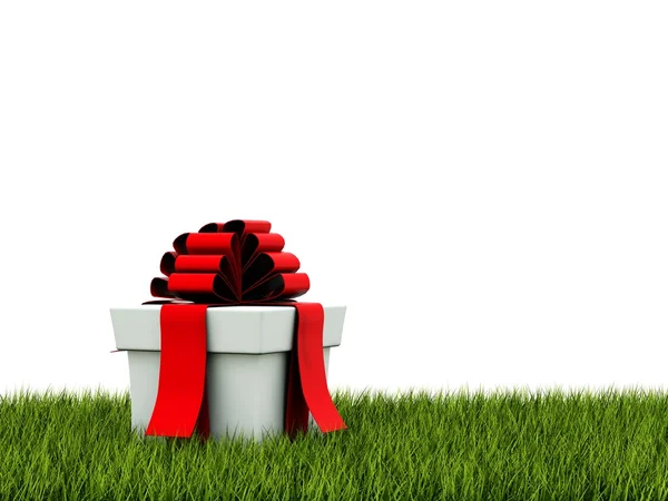 Presente com fita vermelha na grama verde — Fotografia de Stock