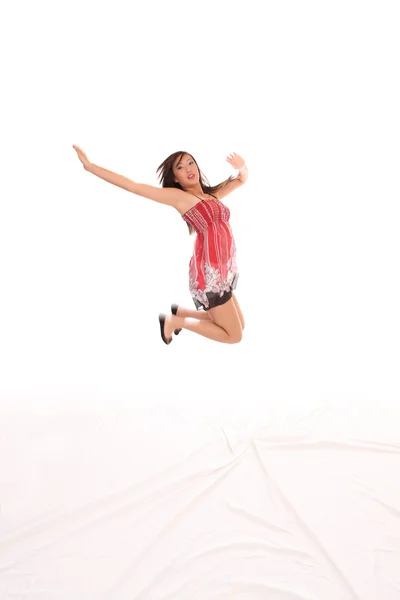 Genç Asyalı Amerikalı genç kadın kırmızı elbise atlama — Stok fotoğraf