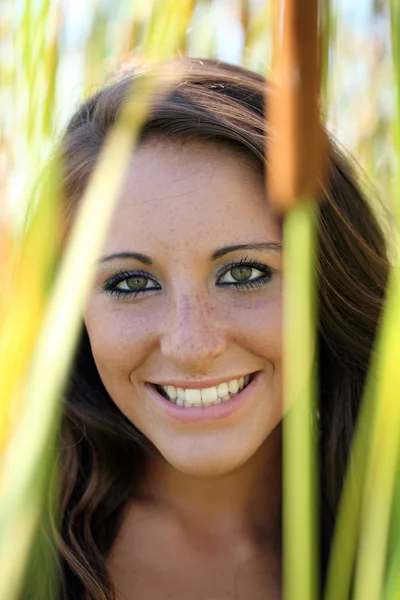 Smiling teen girl outdoor portrait amid cattails — Stock Photo, Image