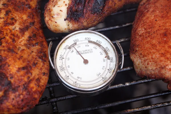 Grill surface thermometer with cooking chicken pieces — Stock Photo, Image