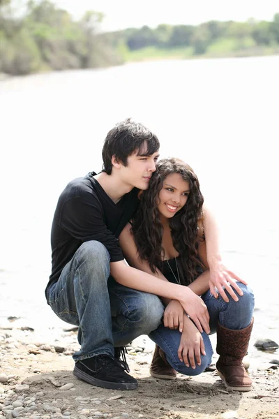 Young teen couple outdoors by river jeans — Stock Photo, Image