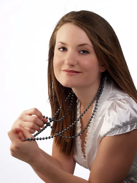 Young woman in white blouse holding bead necklace — Stock Photo, Image