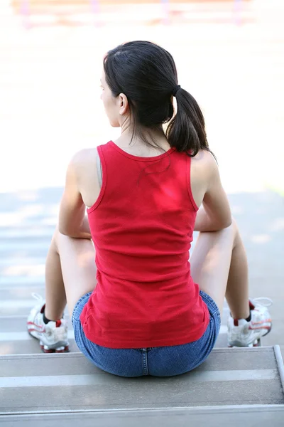 Young latina teen girl sitting on bleachers from back — Stock Photo, Image