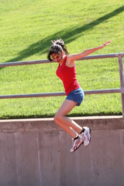 Молодая девушка-подросток прыгает в синих шортах — стоковое фото