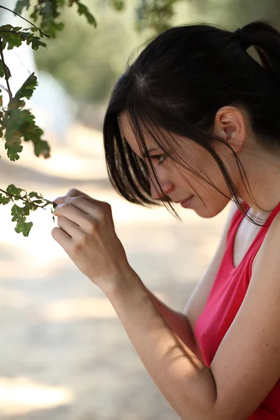 Jovem latina adolescente ao ar livre olhando para a folha de carvalho — Fotografia de Stock