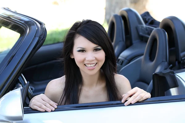 Молодая азиатка, сидящая в кабриолете — стоковое фото