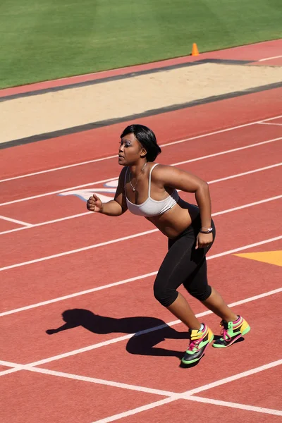 Jovem afro-americana correndo na pista — Fotografia de Stock