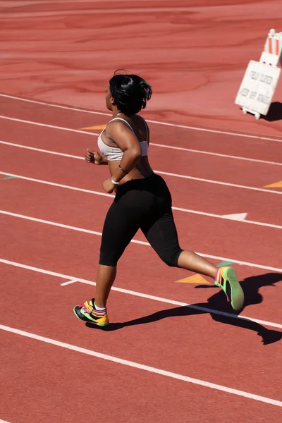Молодая пухлая черная женщина бежит по рельсам — стоковое фото