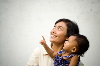 Asian mother and baby looking up and pointing clipart