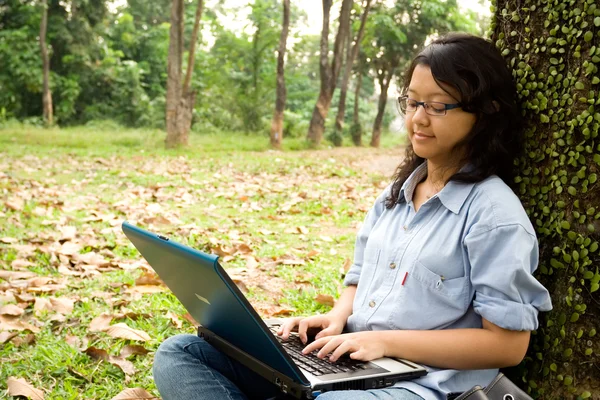 Kvinnliga collegestudent arbetar på en bärbar dator — Stockfoto