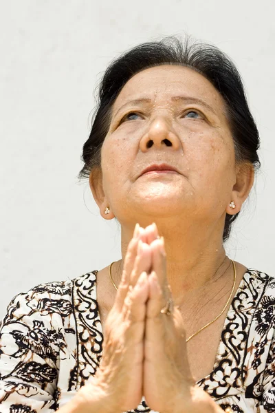 Elderly woman with worship attitude — Stock Photo, Image