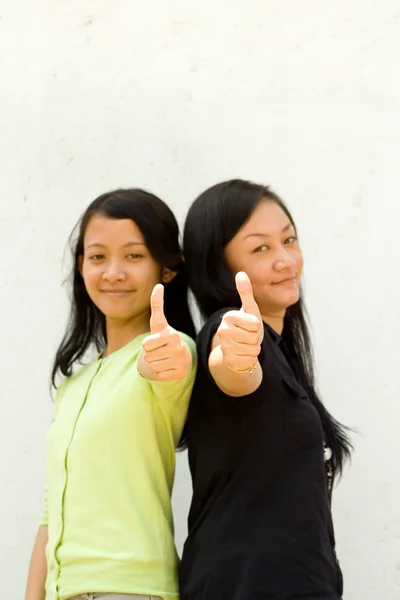 Две девушки поднимают большие пальцы — стоковое фото