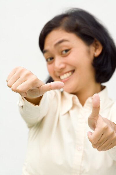 Asian ethnic young business woman smiling and showing two thumbs up