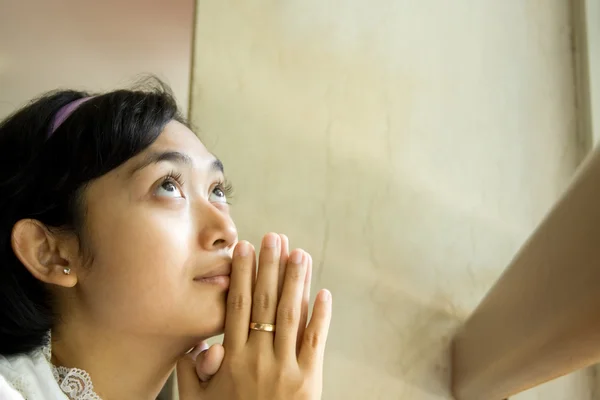 Молодая женщина поклоняется у окна — стоковое фото