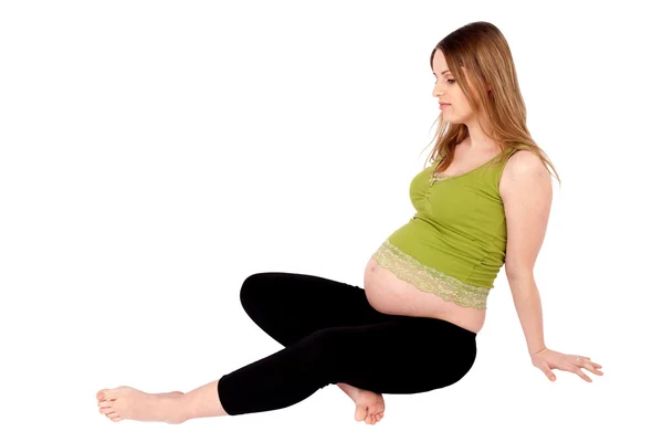 Mujer embarazada sentada en el suelo —  Fotos de Stock