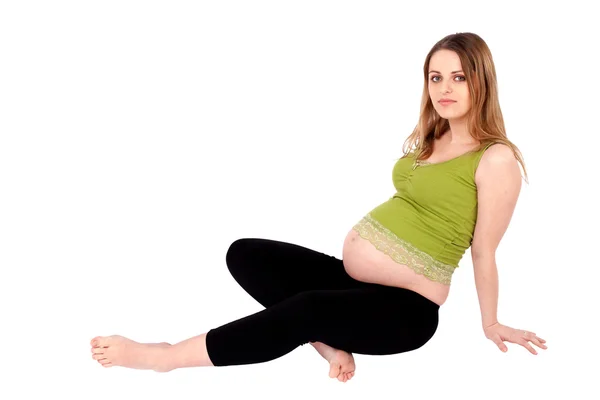怀孕的妇女坐在地上 — 图库照片