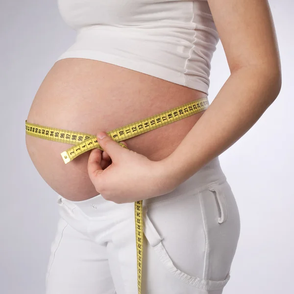 Mulher medindo sua barriga — Fotografia de Stock