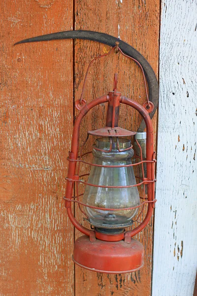 Керосиновая лампа и серп — стоковое фото