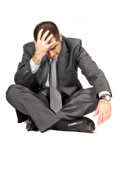 Depressed young businessman sitting on the ground Stock Photo by ...