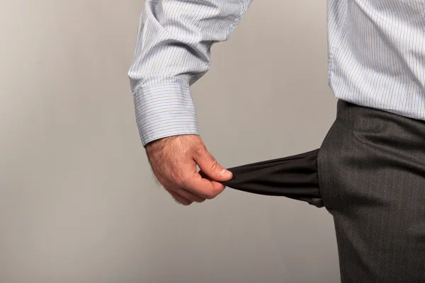 stock image Disappointed businessman with empty pockets isolated over white