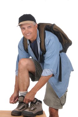 Middle aged man preparing for a hike clipart