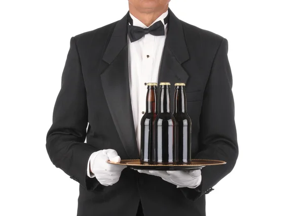 Butler com garrafas de cerveja na bandeja — Fotografia de Stock