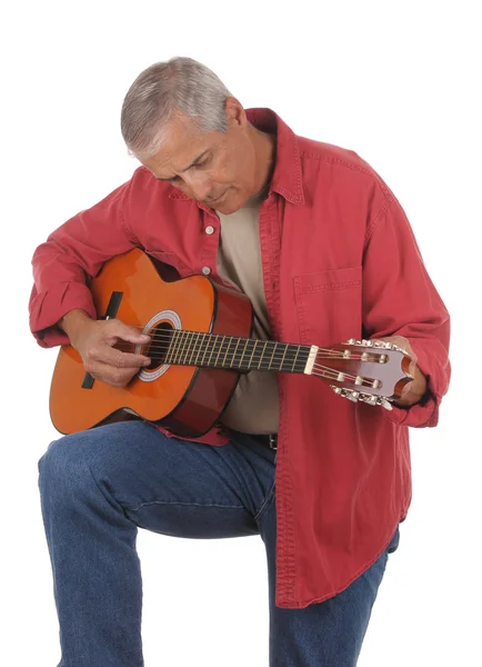 stock image Middle aged man tuning guitar