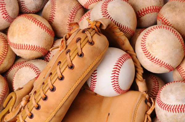 Handschoen op stapel van oude honkballen — Stockfoto